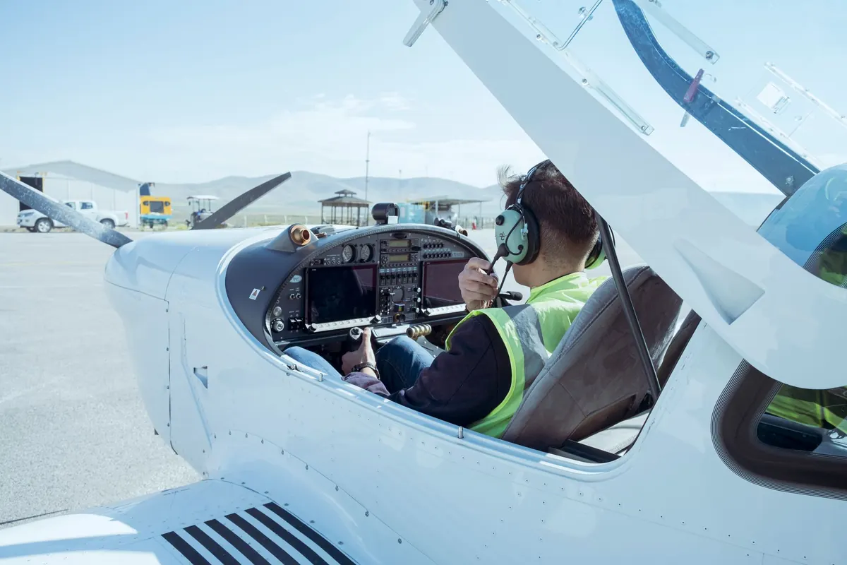Pilot sam w kabinie samolotu szkolnego z otwartą owiewką